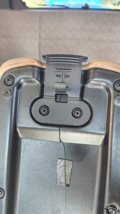 Underside view of replacement latch installed with factory screws on Jeep Cherokee XJ console lid